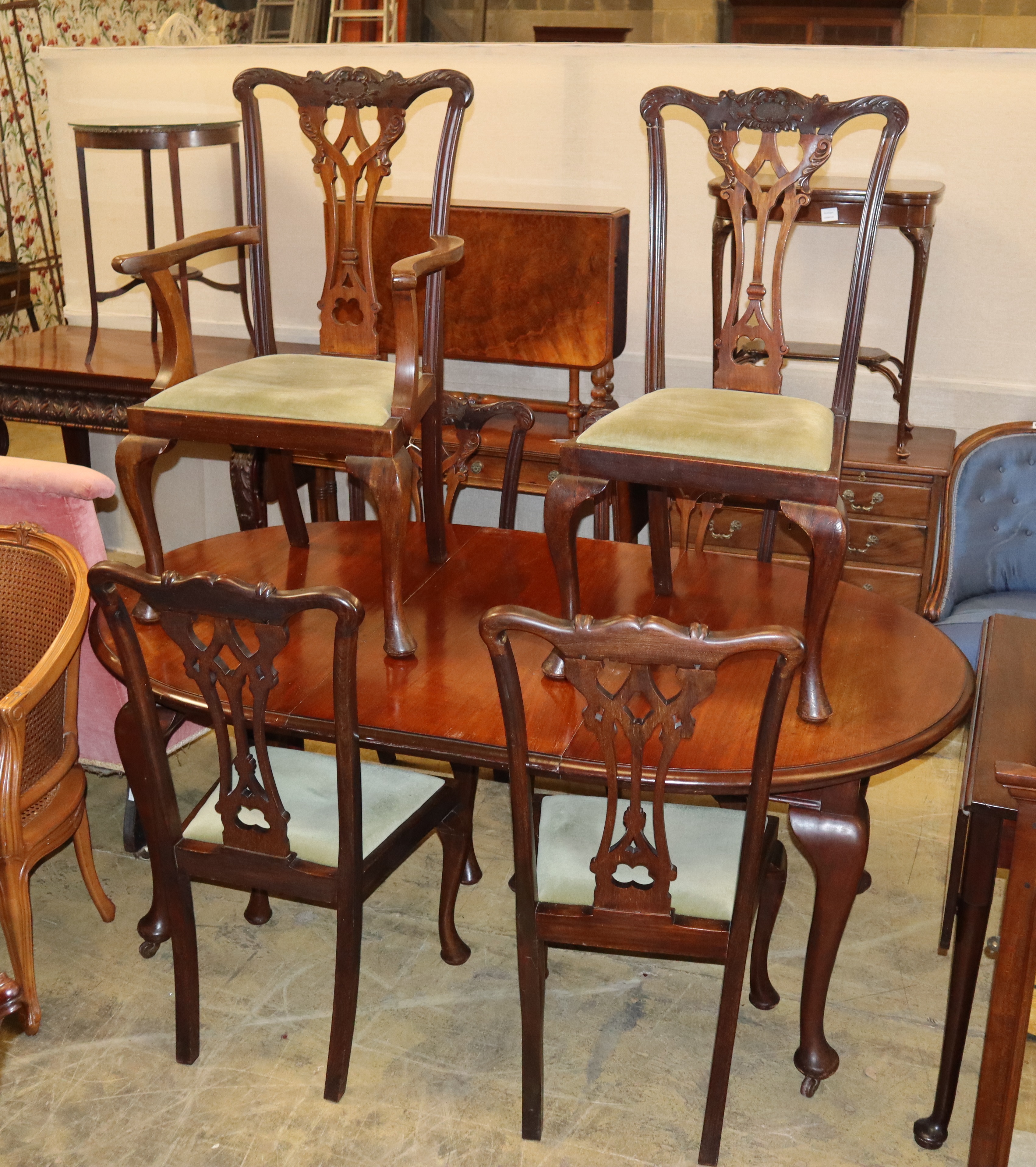 An early 20th century Chippendale revival mahogany dining suite comprising extending dining table and six chairs (one with arms)